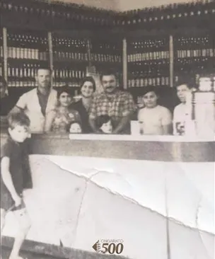 A família Ongarato reunida atrás do balcão do primeiro estabelecimento, em foto de época